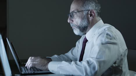 Hombre-De-Negocios-Cansado-Usando-Una-Computadora-Portátil-En-Una-Oficina-Oscura